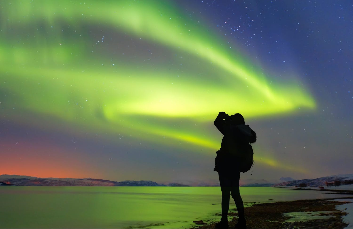 Silhouette,Of,Female,Photographer,Take,A,Photograph,At,Aurora,Borealis